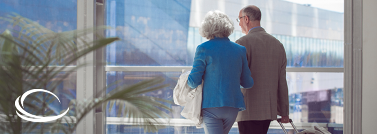 Senior man and woman walking together at the airport