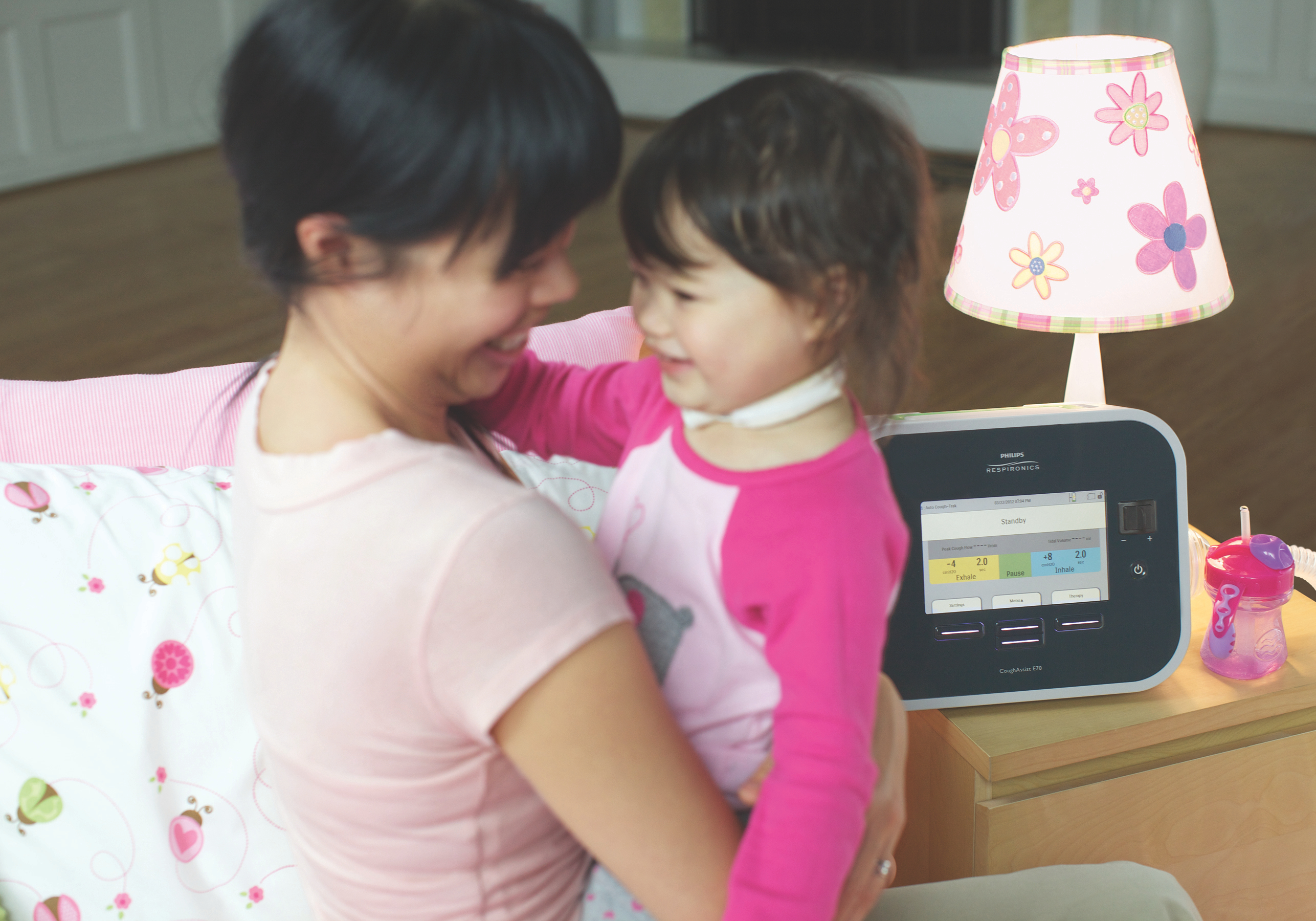 Photo of a mom and daughter and the daughter uses the CoughAssist.