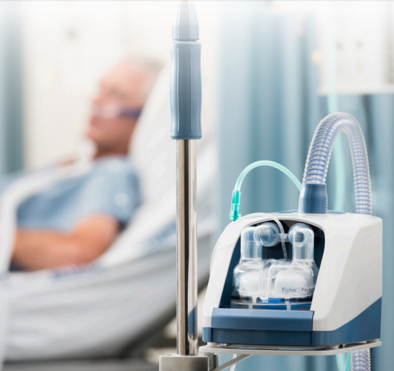 Photo of the AIRVO 2 on a table with a patient in the background.