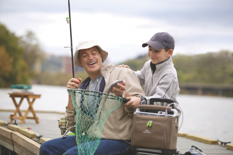 Photo of the SimplyGo Portable Oxygen Concentrator with a person outside fishing.