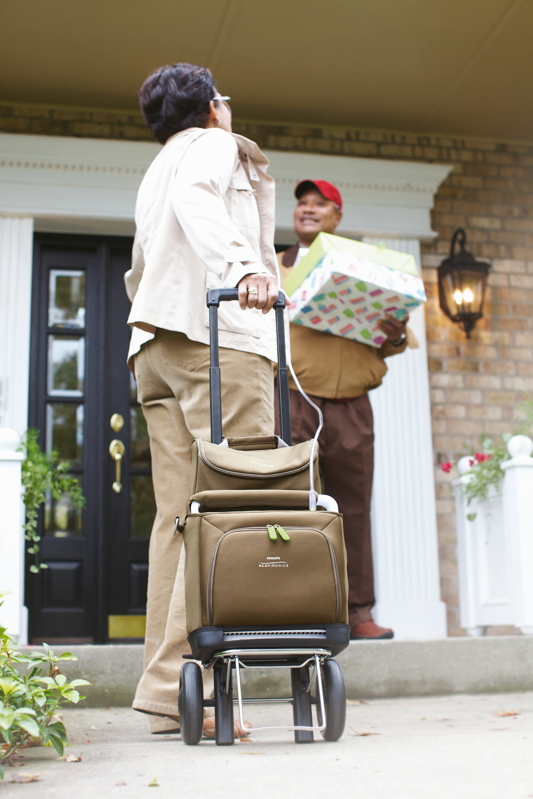 Photo of the SimplyGo Portable Oxygen Concentrator in the bag and cart with a person using it.
