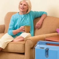 Photo of a woman using the EverFlo Q Stationary Oxygen Concentrator in her home. thumbnail