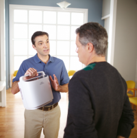 Photo of the SimplyGo Portable Oxygen Concentrator being presented by a person. thumbnail