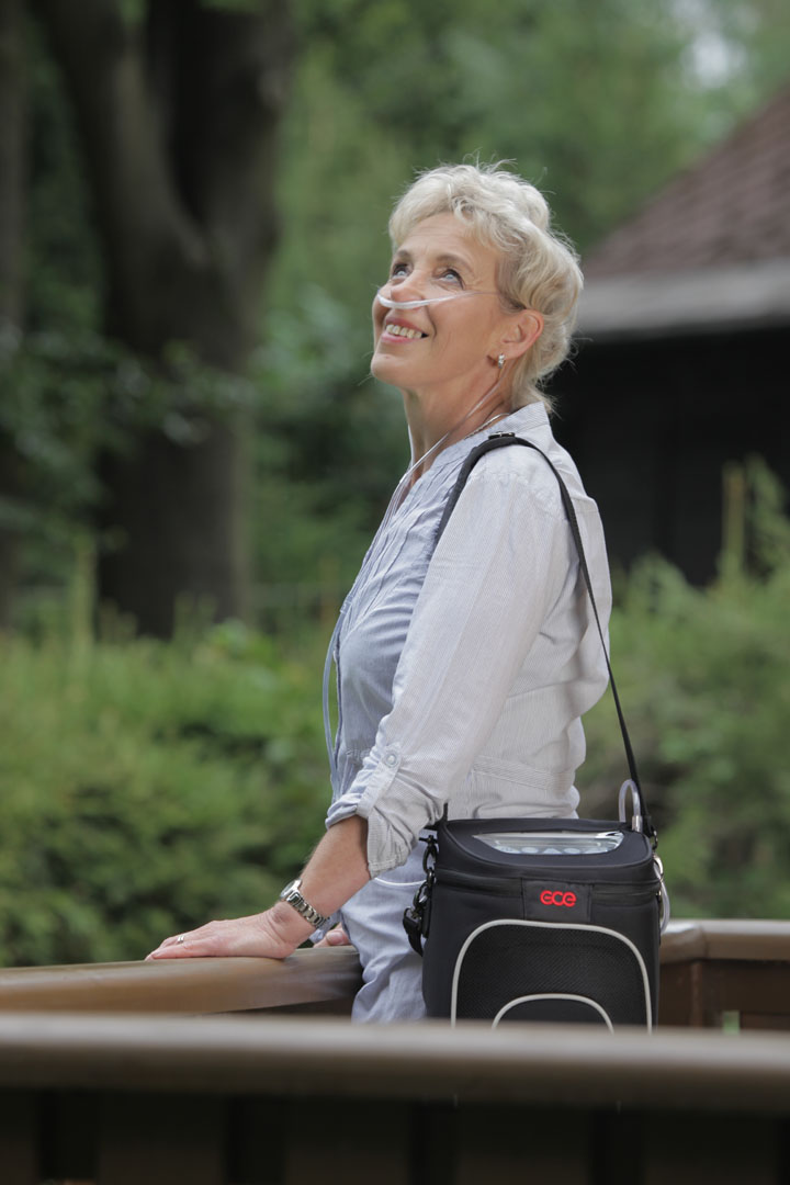 Photo of a woman carrying the Zen-O Portable Oxygen Concentrator outside.